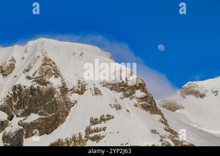 Blick auf den fast Vollmond, der über schneebedeckten Bergen auf der Antarktischen Halbinsel, Antarktis und Polarregionen aufsteigt Stockfoto