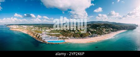 Panoramablick auf den weißen Sand von Praia Grande, dem größten Strand an der Sintra-Küste, mit dem Meerwasserpool des Arribas Hotels, dem größten in Europa Stockfoto