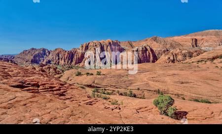 Die Red Mountains, die sich hinter den versteinerten Sanddünen im Snow Canyon State Park im Süden Utahs erheben Stockfoto