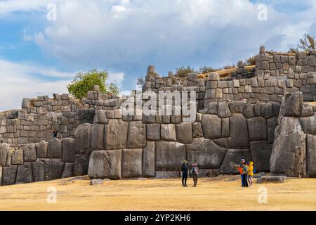 Touristen an der Steinmauer an der archäologischen Stätte Sacsayhuaman, UNESCO-Weltkulturerbe, Cusco, Region Cusco, Peru, Südamerika Stockfoto