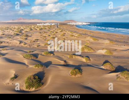 Aus der Vogelperspektive auf einen Touristen und Sanddünen von Famara Beach bei Sonnenaufgang, Caleta de Famara, Las Palmas, Lanzarote, Kanarische Inseln, Spanien, Atlantik, Europa Stockfoto