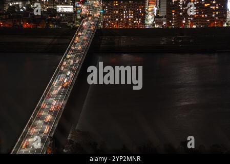 Verkehr auf Brücken, die den Yodo überqueren, und die Skyline von Osaka, Honshu, Japan und Asien um Mitternacht Stockfoto