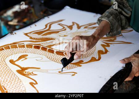 Frau, die heißes Wachs benutzt, um ein Drachendesign zu skizzieren, Batikproduktion, Yogyakarta, Java, Indonesien, Südostasien, Asien, Asien Stockfoto