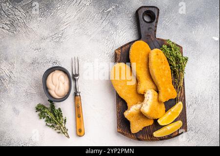 Frittierte Fischfinger auf Holzbrett. Weißer Hintergrund. Draufsicht. Stockfoto