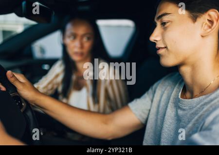 Seitenansicht eines jungen Mannes, der mit Mutter Auto fährt Stockfoto
