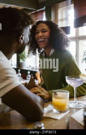 Glückliche junge Frau genießt das Date mit einem Freund in der Bar Stockfoto