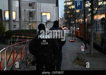 Berlin, Deutschland. November 2024. Basketball: Euroleague, Alba Berlin - Maccabi Tel Aviv, Hauptrunde, Spieltag 12 in Berlin. Polizeibeamte bewachen den Alba Berlin-Mannschaftsbus vor dem Spiel. Das Basketballspiel Maccabi Tel Aviv in Berlin steht aufgrund der Angst vor anti-israelischen und antisemitischen Protesten unter besonderem Polizeischutz. Quelle: Philip Dulian/dpa/Alamy Live News Stockfoto