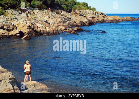 Ein junges Paar genießt an einem Sommertag einen romantischen Tag an der Küste von Maine mit Blick auf das Meer Stockfoto