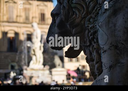 Verschwommener Blick auf die Piazza della Signoria in Florenz, hinter der Silhouette einer Löwenkopfstatue Stockfoto