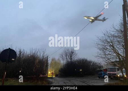 Vilnius, Litauen. November 2024. Ein Flugzeug fliegt über die abgesicherte Absturzstelle. Die Ermittler in Litauen gehen davon aus, dass die Daten des Flugdatenschreibers und des Sprachschreibers des abgestürzten Frachtflugzeugs aus Deutschland in naher Zukunft ausgelesen werden können. Quelle: Alexander Welscher/dpa/Alamy Live News Stockfoto