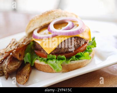 Cheeseburger mit Pommes und Ketchup auf rustikalem Tisch Stockfoto