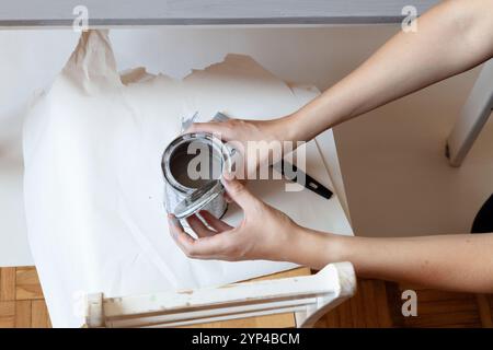 Die Frau hält die Farbdose, bevor sie schließt. Nahaufnahme Stockfoto