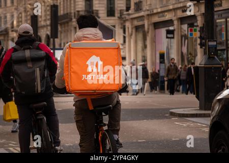 LONDON - 25. NOVEMBER 2024: Einfach essen Lieferperson auf einem Fahrrad in der Oxford Street im Zentrum von London Stockfoto