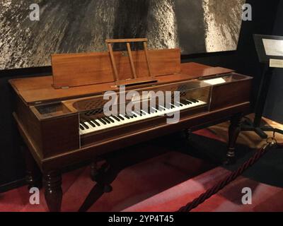 Dieses historische Klavier wird in der Siestapixel-Galerie gezeigt und zeigt sein kompliziertes Design und seine handwerkliche Verarbeitung. Besucher bewundern die einzigartige hölzerne Oberfläche und Stockfoto