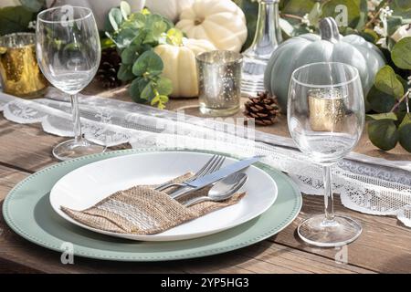 Thanksgiving-Tagestisch mit Herbstdekoration, Kürbisse auf Holztisch. Festliches Familienessen im Innenraum. Nahaufnahme. Feiertagstisch Stockfoto