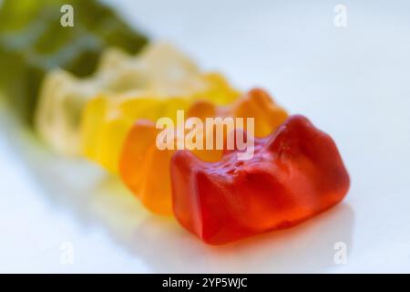 Detailstudio, aufgenommen aus einer Reihe von bunten Jelly Bären aus Perspektive. Es ist auf einem sauberen weißen Hintergrund. Konzept von süßem Essen, Genuss und Stockfoto