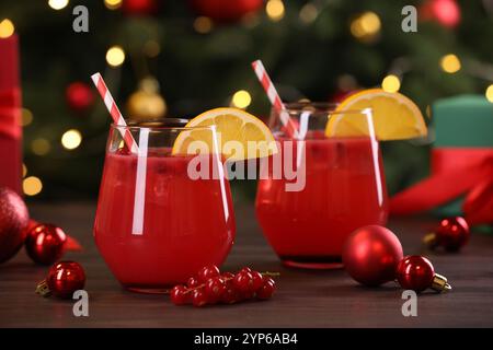 Weihnachtscocktail in Gläsern mit Zitrone und Johannisbeeren auf Holztisch Stockfoto