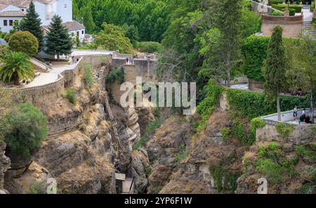 Puente Viejo Brücke in Ronda, mit mehreren Terrassen und Aussichtspunkten, mit Feldern und Bergen im Hintergrund Stockfoto