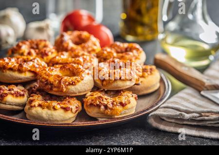 Mini-Pizza-Bagels auf Teller auf einem schwarzen Tisch. Stockfoto