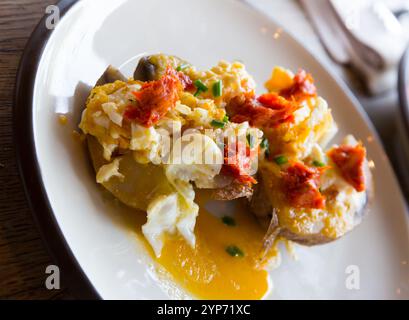 Gegrillte Kartoffel mit würziger Wurstpastete und Eiern, auf dem Teller Stockfoto