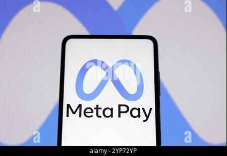 In dieser Fotoabbildung wird das Meta Pay-Logo auf einem Smartphone und im Hintergrund das Meta Platforms-Logo angezeigt Stockfoto
