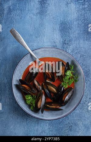 FRA Diavolo Muscheln, Muscheln in Tomatensauce, italienisches Gericht, auf blauem Hintergrund, hausgemacht, keine Leute Stockfoto