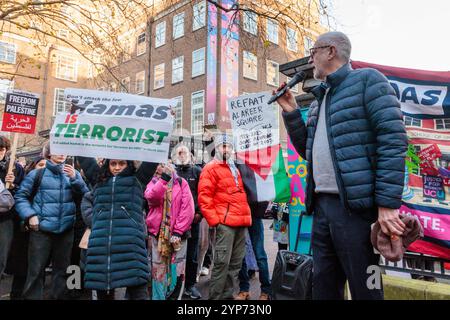 SOAS, London, Großbritannien. November 2024. Der Pro-Israel-Anhänger hält ein Poster mit dem Titel "HAMAS IST TERRORIST", während der ehemalige Labour-Parteichef Jeremy Corbyn eine Rede auf einer Kundgebung außerhalb der Schule für Orientalische und Afrikanische Studien (SOAS) hält, um Palästina zu unterstützen. Quelle: Amanda Rose/Alamy Live News Stockfoto