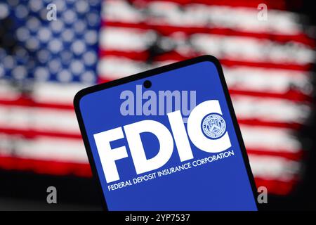 In dieser Abbildung wird das Logo der Federal Deposit Insurance Corporation (FDIC) auf einem Smartphone-Bildschirm und im Hintergrund die Flagge o angezeigt Stockfoto