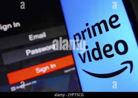 In dieser Fotoabbildung wird das Amazon Prime Video Logo auf einem Smartphone-Bildschirm neben einem Anmeldebildschirm mit E-Mail, Passwort und Anmeldung angezeigt Stockfoto