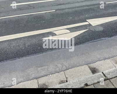 Weiße Richtungspfeile auf einer Straße Stockfoto