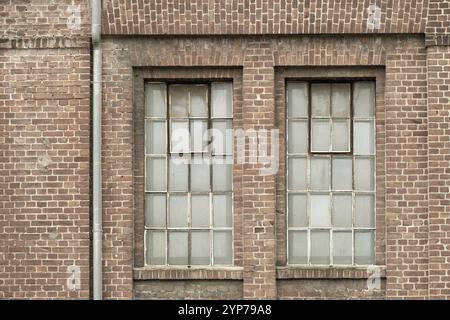 Details eines alten Industriegebäudes, Backsteinmauer und Fenster, ca. 100 Jahre alt Stockfoto