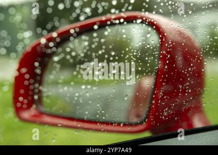 Roter Außenspiegel eines Autos im Regen Stockfoto