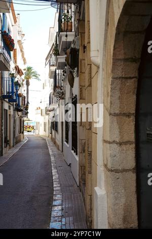 Eine schmale Straße mit Blick auf das Meer in Sitges, einem wunderschönen Ferienort in Katalonien, Spanien Stockfoto