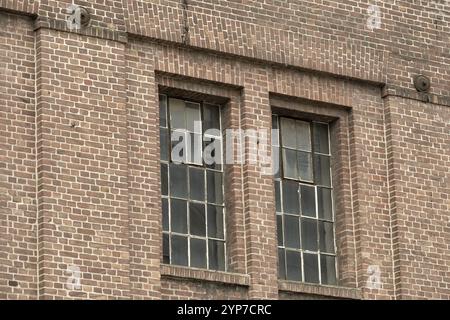 Details eines alten Industriegebäudes, Backsteinmauer und Fenster, ca. 100 Jahre alt Stockfoto