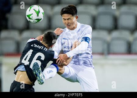 Thun, Schweiz. November 2024. Luganos Mattia Zanotti und Gents Tsuyoshi Watanabe kämpfen um den Ball während eines Fußballspiels zwischen dem Schweizer FC Lugano und der belgischen KAA Gent am Donnerstag, den 28. November 2024 in Thun, Schweiz, am vierten Tag der Gruppenphase des UEFA Conference League-Turniers. BELGA FOTO JASPER JACOBS Credit: Belga News Agency/Alamy Live News Stockfoto