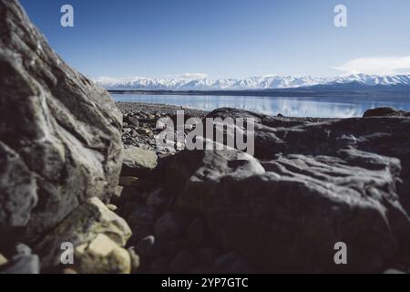 Große Felsen an einem felsigen Ufer mit See und Bergen im Hintergrund, Lake Pukaki, Neuseeland, Ozeanien Stockfoto