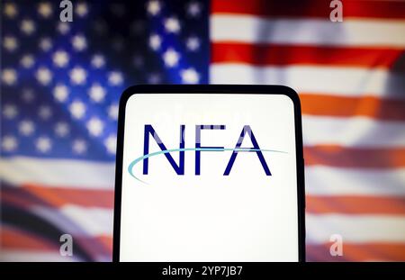 In dieser Fotoabbildung wird das Logo der United States National Futures Association (NFA) auf einem Smartphone-Bildschirm mit einer US-Flagge in angezeigt Stockfoto