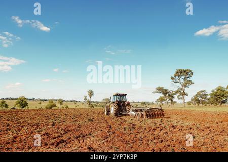 Ein Valtra-Traktor pflügt Boden für den Einsatz in der Landwirtschaft auf einem ländlichen Grundstück in Brasilien Stockfoto
