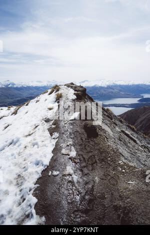 Verschneite Berggipfel mit beeindruckendem Blick auf einen See und Bergketten, Roys Peak, Wanaka, Neuseeland, Ozeanien Stockfoto