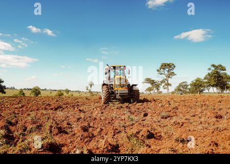 Ein Valtra-Traktor pflügt Boden für den Einsatz in der Landwirtschaft auf einem ländlichen Grundstück in Brasilien Stockfoto