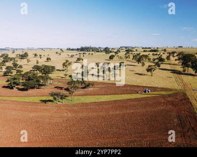 In diesem Luftbild pflügt ein LS-Traktor Boden für den Einsatz in der Landwirtschaft auf einem ländlichen Grundstück in Brasilien Stockfoto