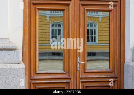 Verzerrte Realität: Reflexionen auf dem hölzernen Türrahmen Stockfoto