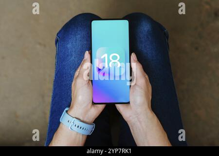 In dieser Abbildung wird das iOS 18-Logo auf einem Smartphone-Bildschirm angezeigt Stockfoto