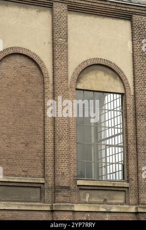 Details eines alten Industriegebäudes, Backsteinmauer und Fenster, ca. 100 Jahre alt Stockfoto