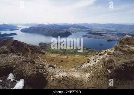 Breites Panorama eines Tals mit einem sich ausbreitenden See umgeben von Hügeln, Roys Peak, Wanaka, Neuseeland, Ozeanien Stockfoto