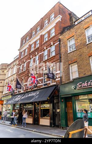 London, Großbritannien – 19. September 2024: Historischer Londoner Pub mit Union Jacks, der den authentischen Charme und Charakter der belebten Straßen von Soho einfängt. Stockfoto