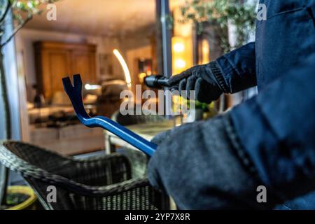 Symbolbild Wohnungseinbruch, Täter späht von der Gartenseite her, eine Wohnung aus, Einbrecher *** Symbolbild eines Einbruchs, Täter spioniert eine Wohnung von der Gartenseite aus, Einbrecher Stockfoto