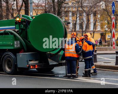 Kanalarbeiter reinigen das Mannloch und lösen die Blockierung von Kanälen Stockfoto