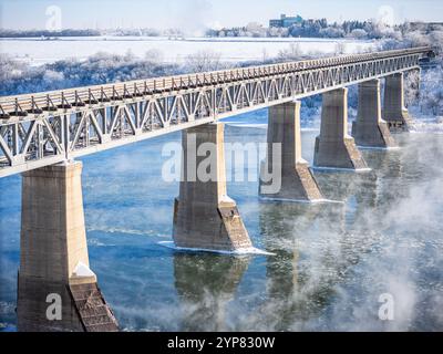 Eine Brücke über einen Fluss mit Nebel im Hintergrund. Die Brücke besteht aus Stein und ist sehr lang Stockfoto