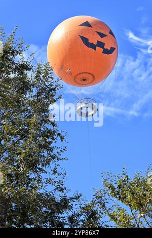 IRVINE, KALIFORNIEN - 11. OCT 2024: Die Ballonfahrt, dekoriert für Halloween, erhebt sich über Bäume im Great Park in Orange County. Stockfoto